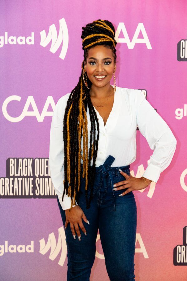 Chef Joya standing in front of a bright pink step and repeat