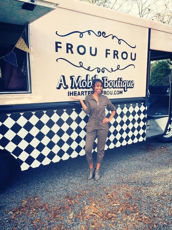 A woman posing in front of a food truck.
