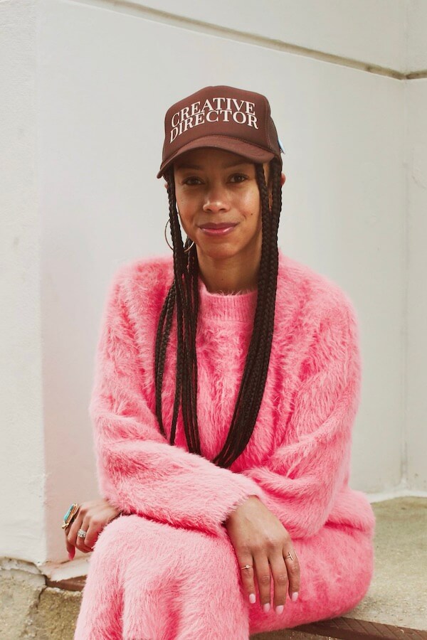 A woman wearing a pink dress and a hat.