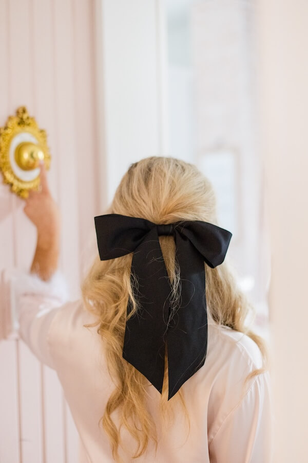 blonde model wearing black hair bow