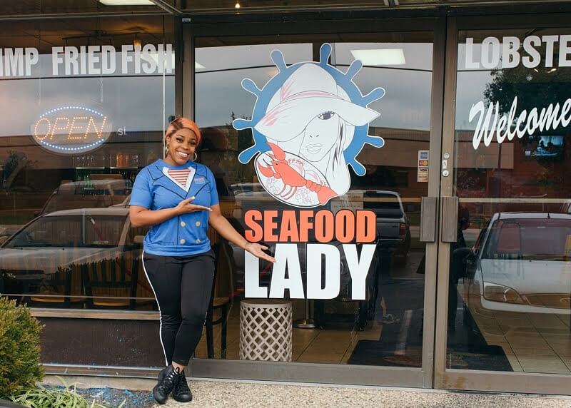 woman smiling in front of a restaurant