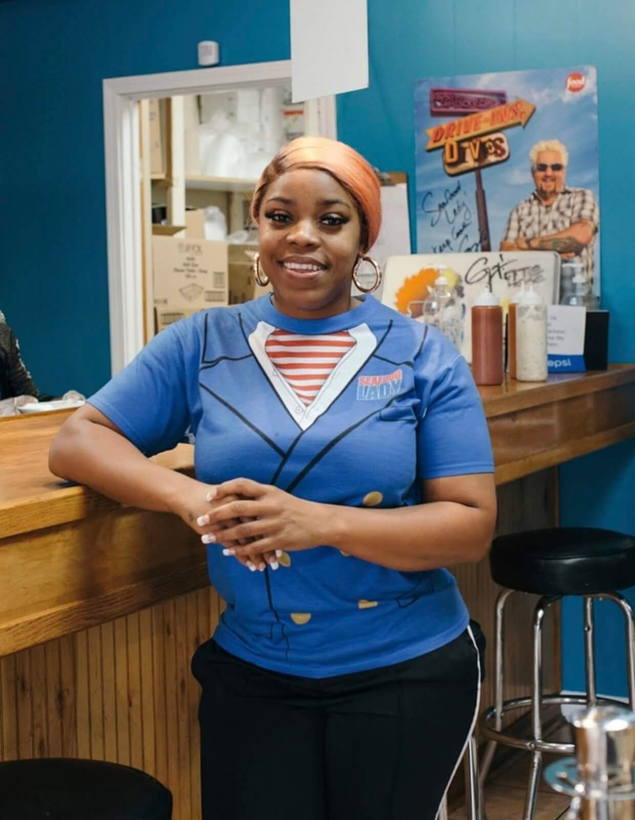 seafood lady leaning up against a bar in a restaurant and smiling