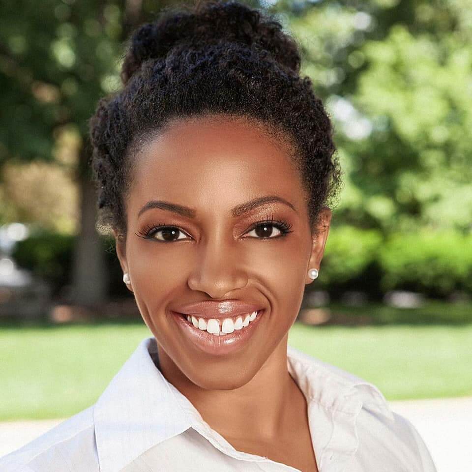 Woman with hair in bun, smiling at camera