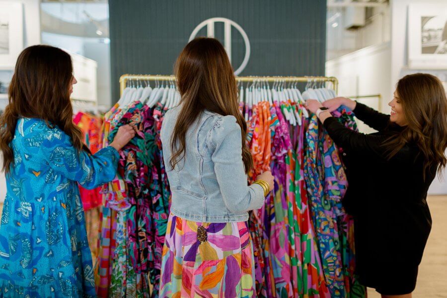 Three Briton Court founders browsing through clothes on a rack.