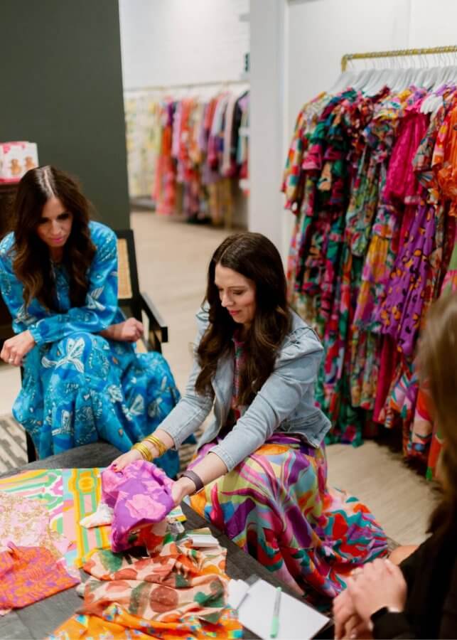 Briton Court founder looking at colorful fabric.