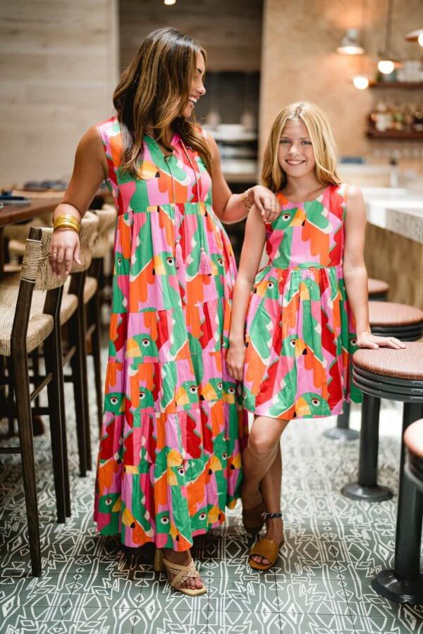 A woman and a girl posing for a picture in matching dresses