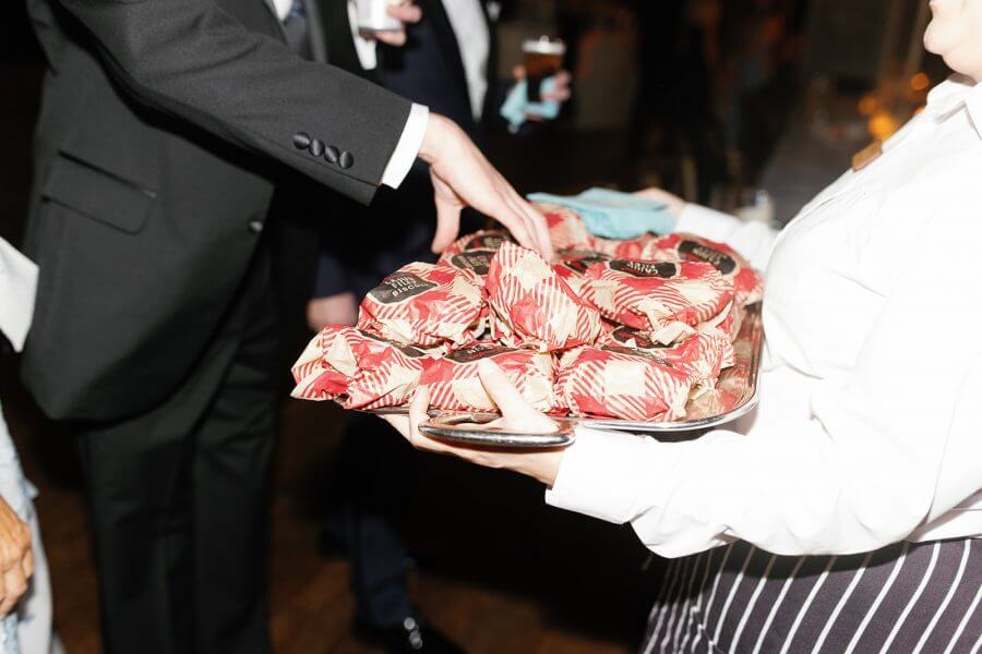 A North Carolina Wedding Dressed in Blues, Bows, and Bojangles - 23 A man taking food from a tray of Bojangles biscuits.