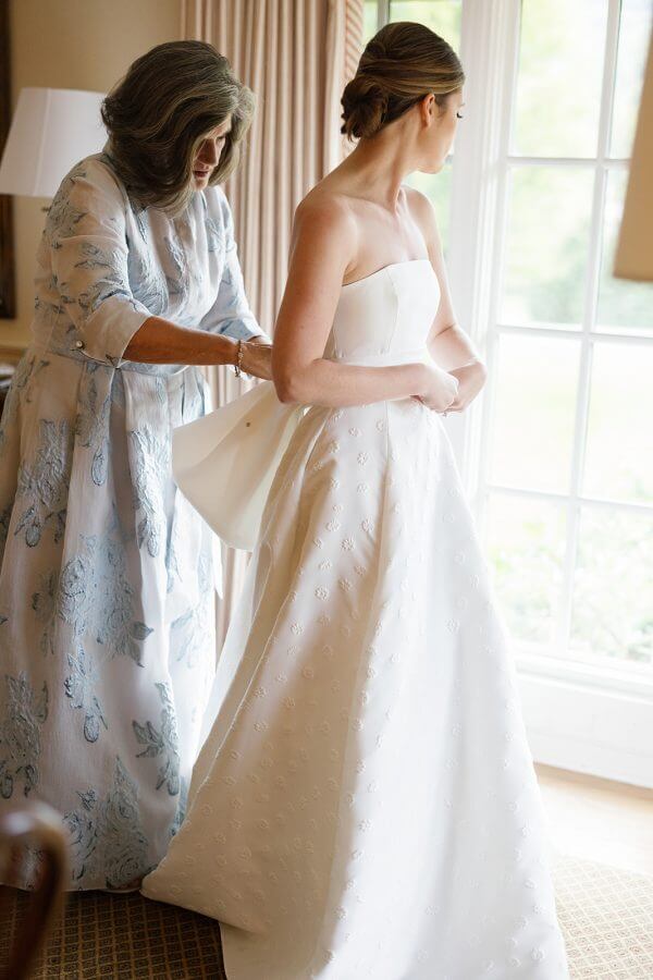 A North Carolina Wedding Dressed in Blues, Bows, and Bojangles - 8 A woman is helping her mother put on a Linville wedding dress.