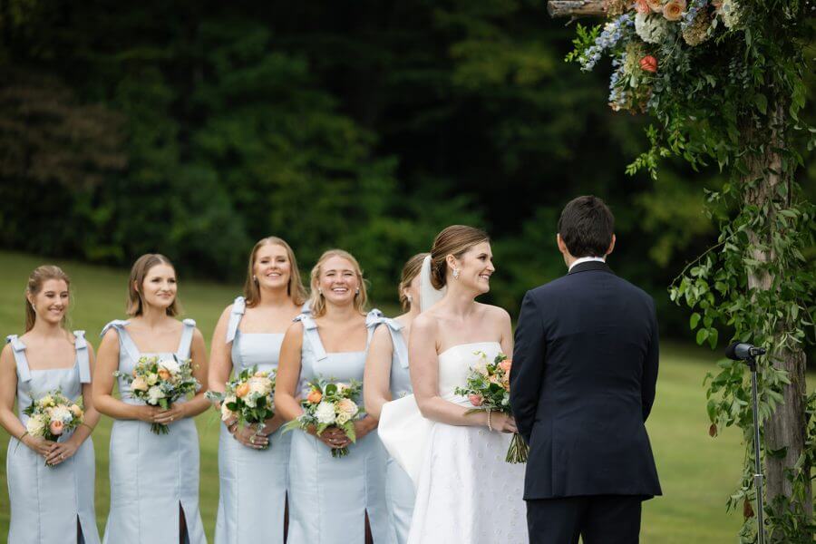 A North Carolina Wedding Dressed in Blues, Bows, and Bojangles - 15 A bride and her bridesmaids look at each other during the Linville Wedding ceremony.