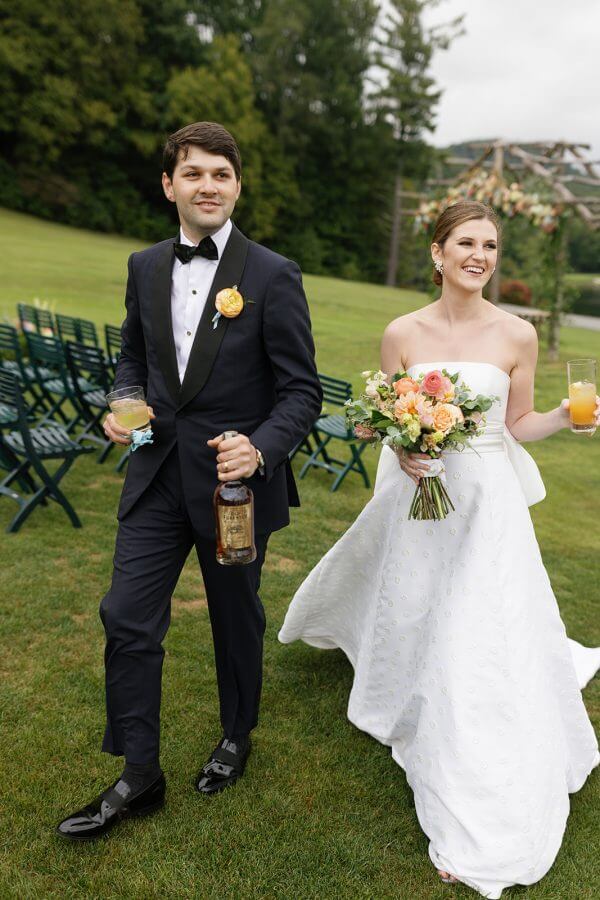 A North Carolina Wedding Dressed in Blues, Bows, and Bojangles - 17 A man and woman walking down the aisle at their Linville wedding.