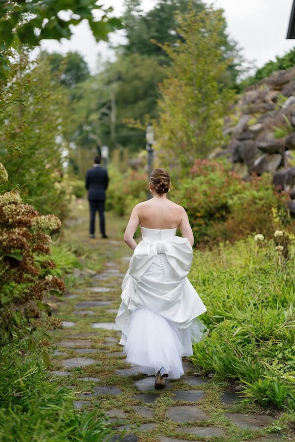 A North Carolina Wedding Dressed in Blues, Bows, and Bojangles - 13 Bride walking towards groom on a North Carolina garden path.