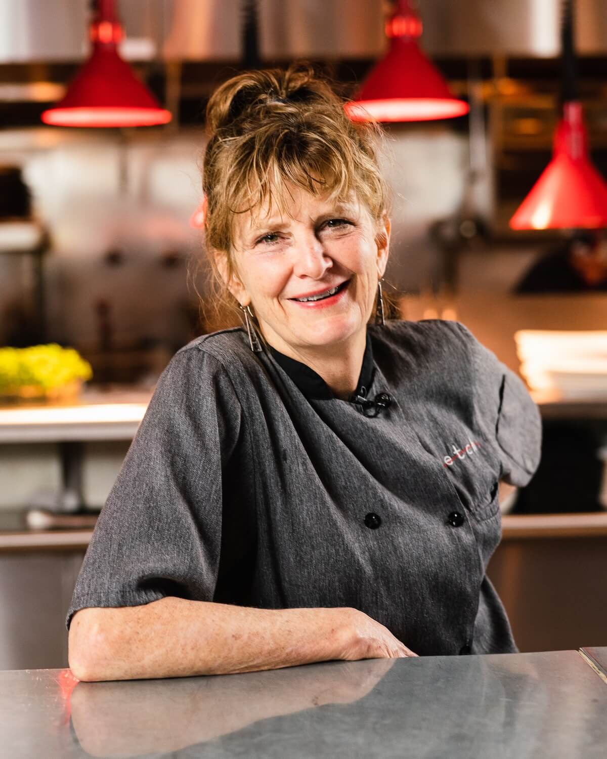 Chef Deb Paquette leaning on restaurant kitchen counter