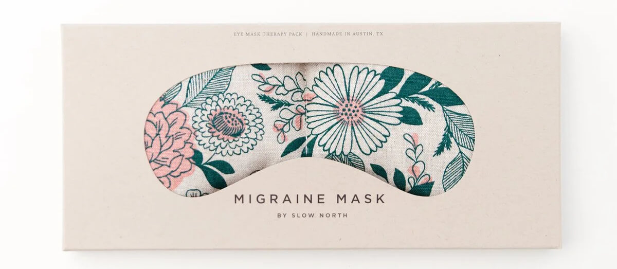 The packaging of the "Migraine Mask" by Slow North, showcased at Nashville FINDS in March, presents a delightful floral design with pink and green flowers peeking through a charming cutout.