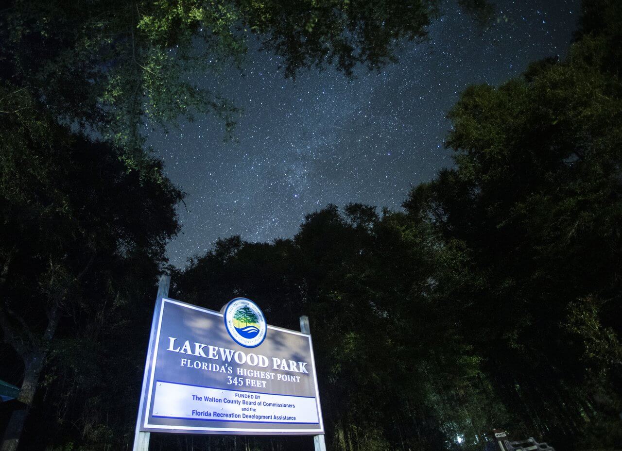 A starry night sky above the sign for lakewood park, indicating florida's highest point at 345 feet.