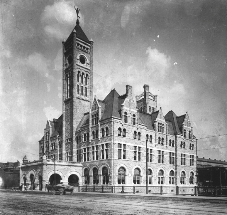 Historic black and white photo of a victorian-era building with a prominent clock tower.