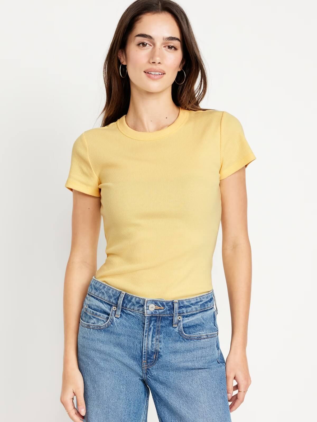 Brunette woman wearing yellow cropped t-shirt with jeans