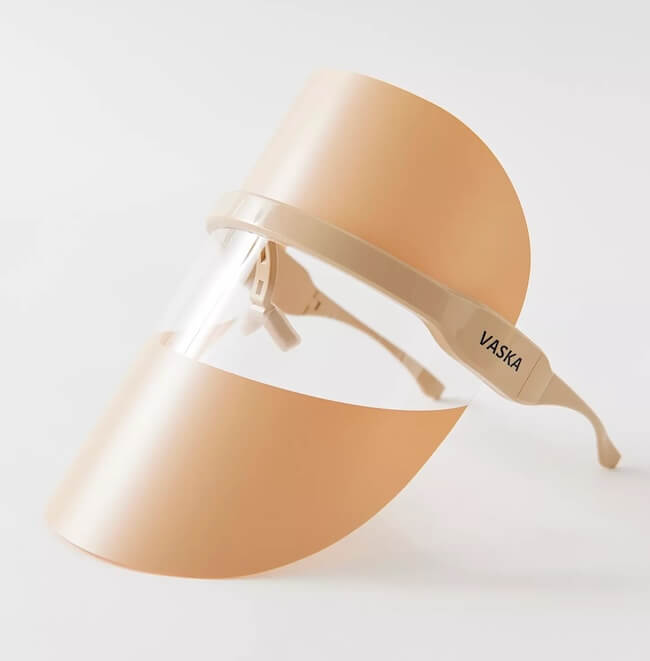 Red light therapy mask with adjustable strap, featuring a clear, tinted upper shield and a white logo on the side.