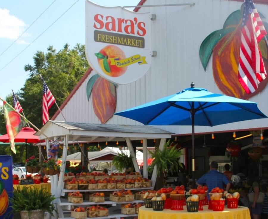 Sara's Freshmarket sign over fruit stands