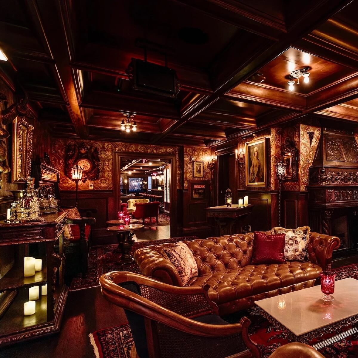 Interior of a luxurious vintage lounge with dark wood panels, leather sofas, intricate paintings, and warm lighting.