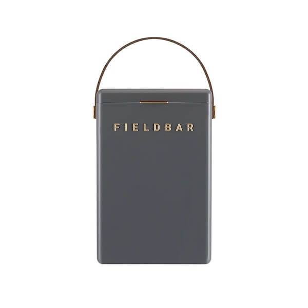 A rectangular, gray Fieldbar cooler box with a gold handle and gold "FIELD BAR" lettering on the front—perfect for those seeking luxe loves in their outdoor essentials.