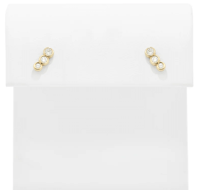 A pair of gold stud earrings, each featuring three small round diamonds in a vertical arrangement, displayed on a white background—perfect for those with luxe loves.