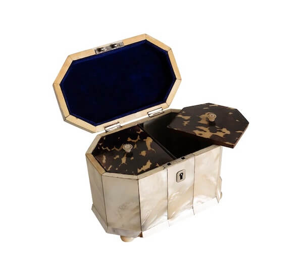 Octagonal tea caddy with a hinged lid, mother-of-pearl and tortoiseshell panels, and blue velvet interior—a true find for luxe loves—set against a white background.