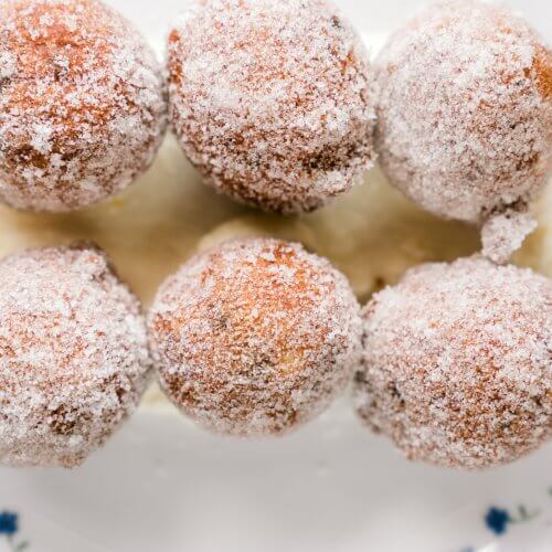 Ricotta Fritters by Coleen Speaks - 1 Six sugar-coated doughnuts, seemingly drafted by an artist's hand, are arranged on a white plate with blue floral patterns.