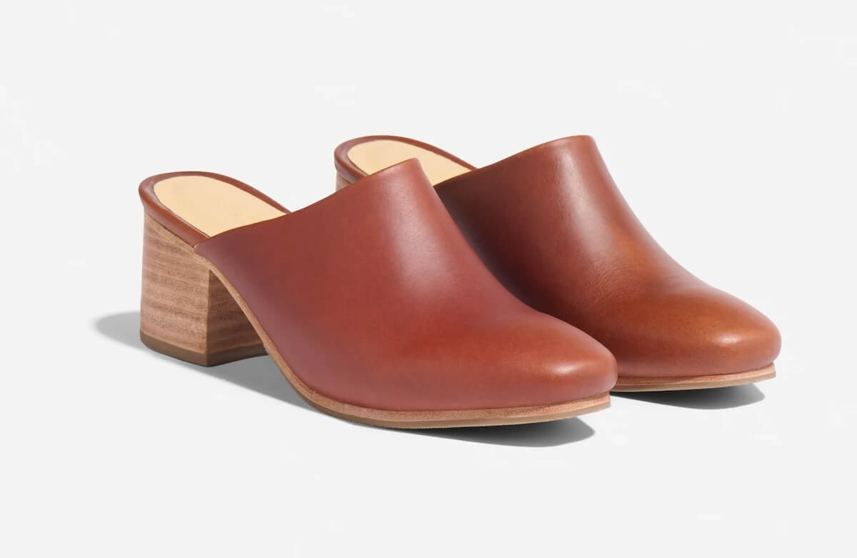 A pair of brown leather open-back clogs with a wooden block heel on a white background, perfect for those crisp September days in Nashville.