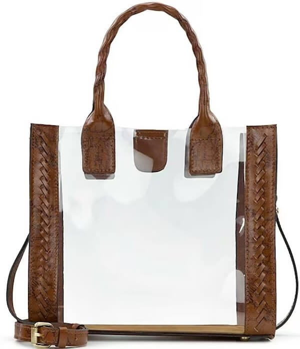 Clear tote bag with brown braided leather trim, handles, and a detachable shoulder strap. This versatile clear bag is perfect for any occasion, providing both style and practicality.