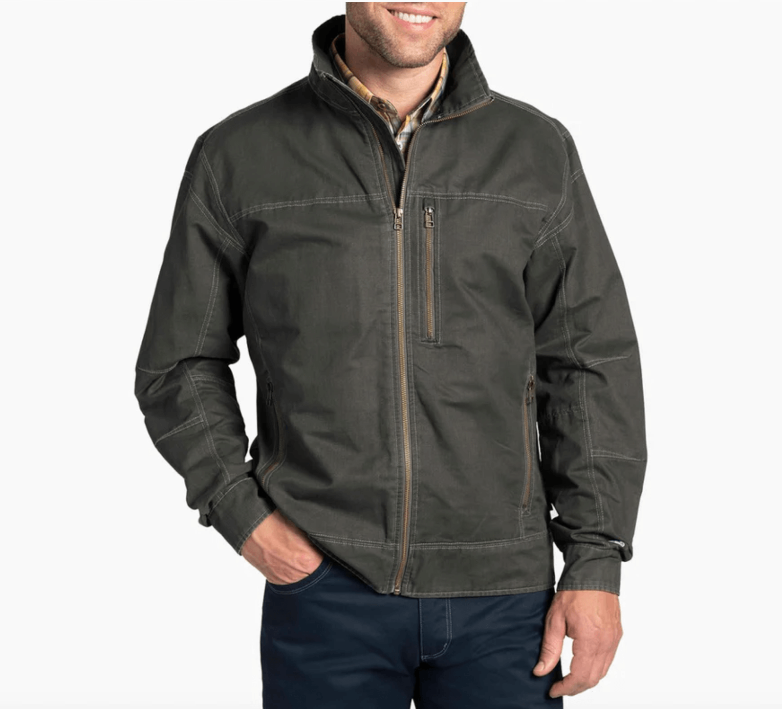 A person wearing a dark green zip-up jacket with a high collar, standing with hands in pockets.