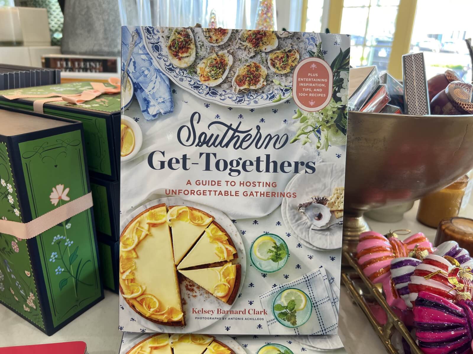 Cookbook titled "Southern Get-Togethers: A Guide to Hosting Unforgettable Gatherings" displayed with decorative items, featuring a pie and drinks on the cover. 