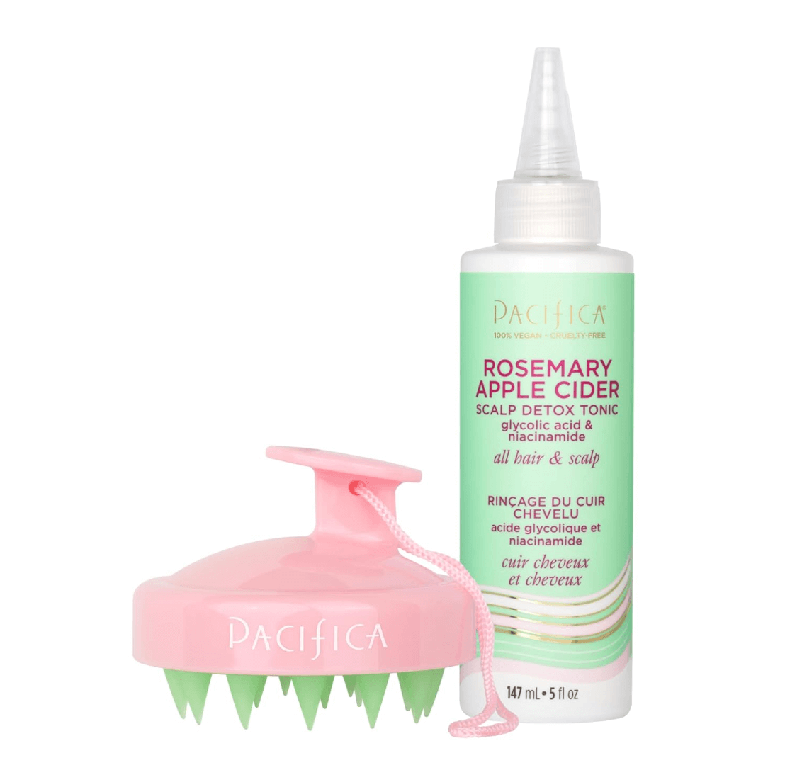 A bottle of Pacifica Rosemary Apple Cider Scalp Detox Tonic and a pink scalp massager with green bristles.