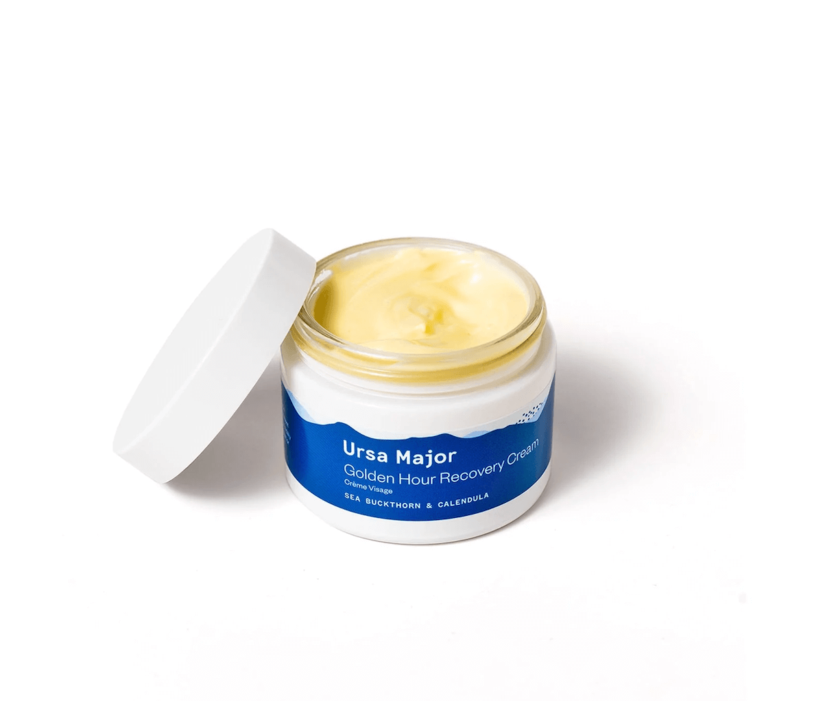Open jar of Ursa Major Golden Hour Recovery Cream with a white lid and blue label, featured in the SB Hot List for January 2025.
