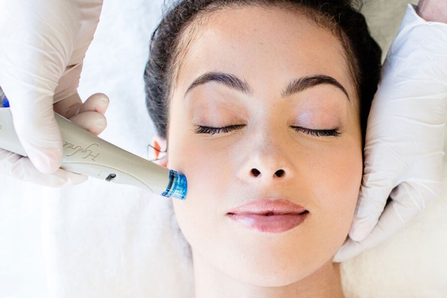 Nashville’s 10 Most Popular Articles of 2025 - 3 A person with closed eyes receives an advanced facial treatment with a small device. Hands in white gloves—experts in skincare—hold the device and gently support their head.