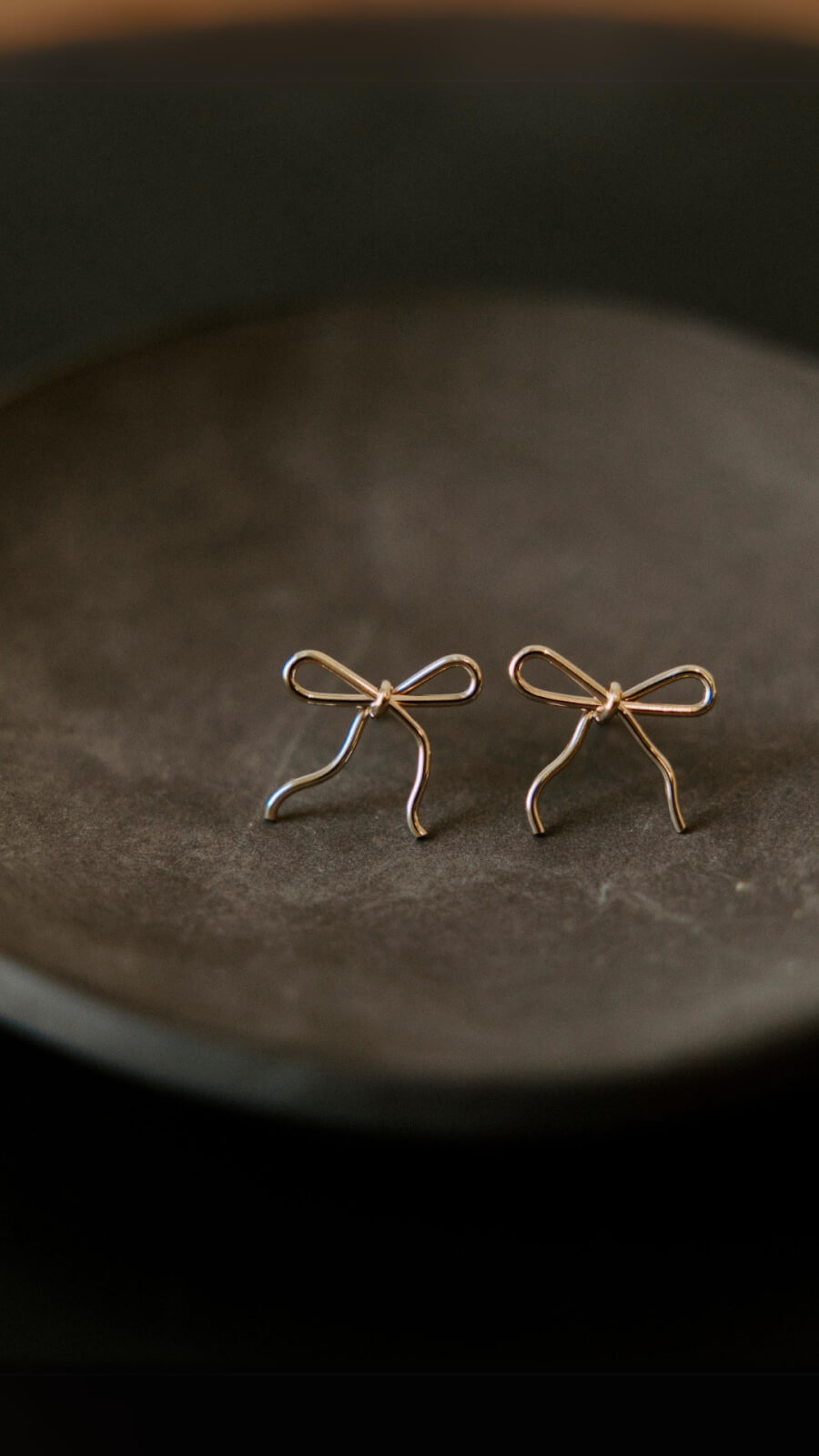 Two dainty bow earrings.
