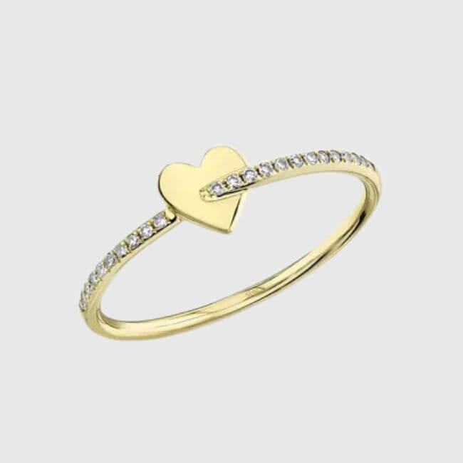 Discover this exquisite gold ring with a diamond-studded band, featuring a small heart-shaped design at the center. One of our February FINDS, it's perfect for adding a touch of elegance to your collection.