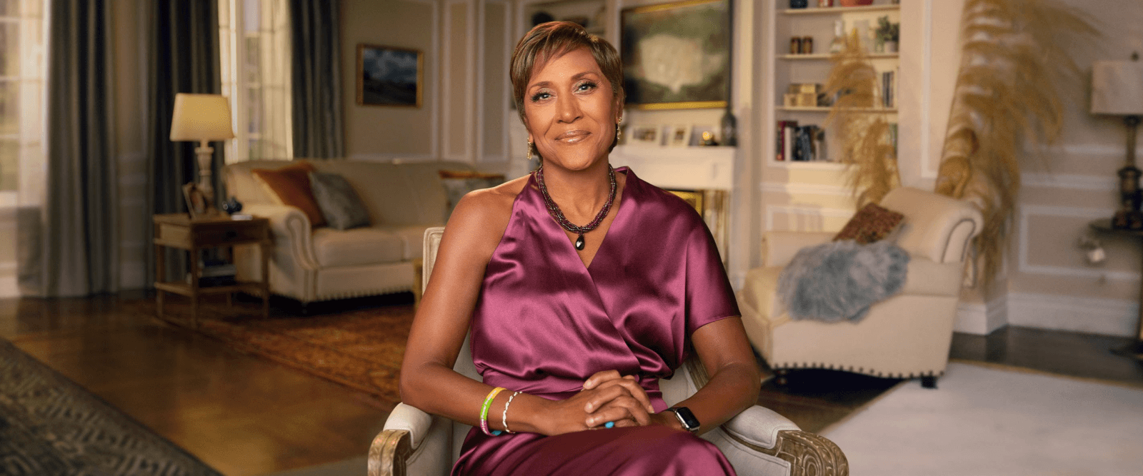 A person in a purple dress sits in a cozy, elegantly furnished living room.