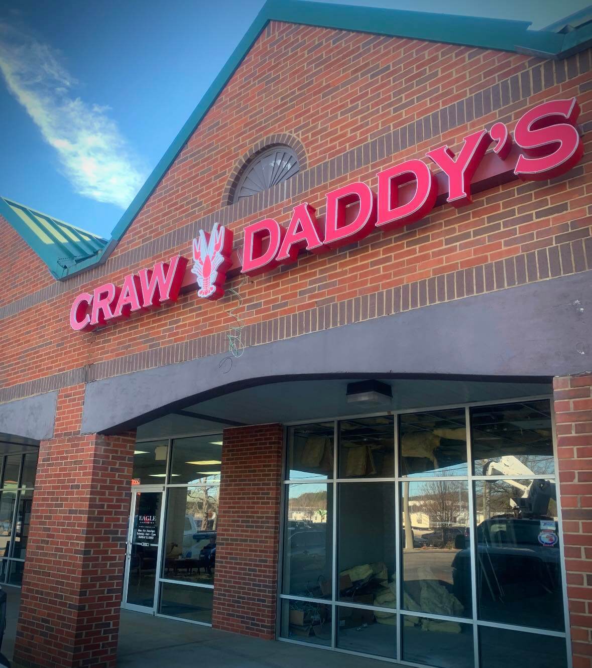 Brick storefront with bold red signage reading "Craw Daddy's," in Pelham.