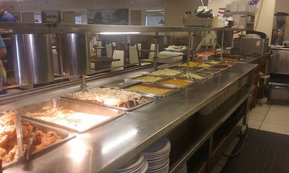 At the White House Restaurant, a buffet line tempts with fried chicken, mashed potatoes, and corn laid out on a metallic counter.