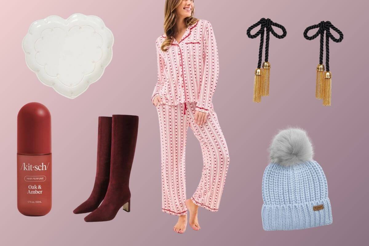 A flat lay of Memphis Finds February gift items: a scalloped dish, a woman in pink pajamas, black tassel earrings, oak & amber perfume, burgundy boots, and a blue knit hat with a pom-pom on a pink background.