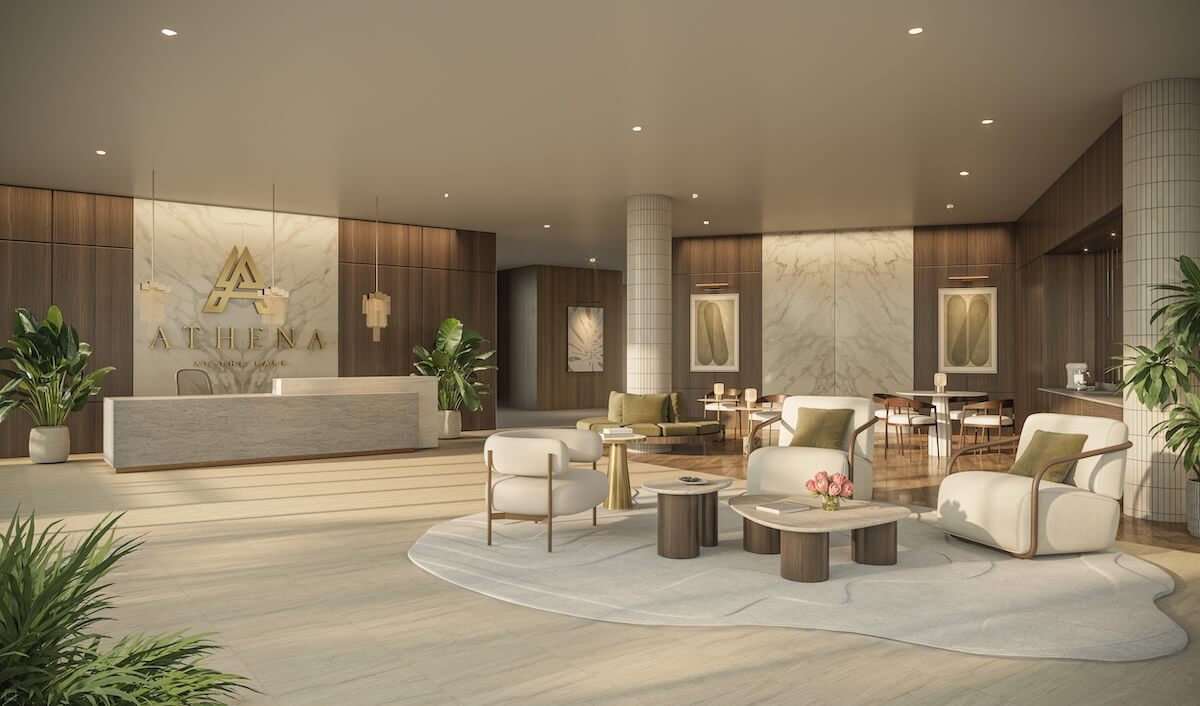Athena at The Park's modern lobby features a sleek reception desk, elegant marble accents, and a cozy seating area adorned with lush plants. The "Athena" logo graces the back wall, embodying sophistication and style.