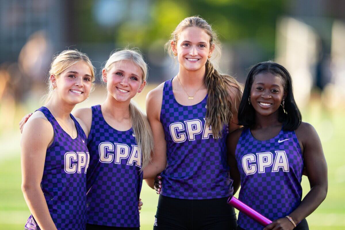 Nashville Private School Open House Dates - 4 Four young women wearing purple βCPAβ athletics uniforms stand together on a field, smiling at the camera; one holds a relay baton.