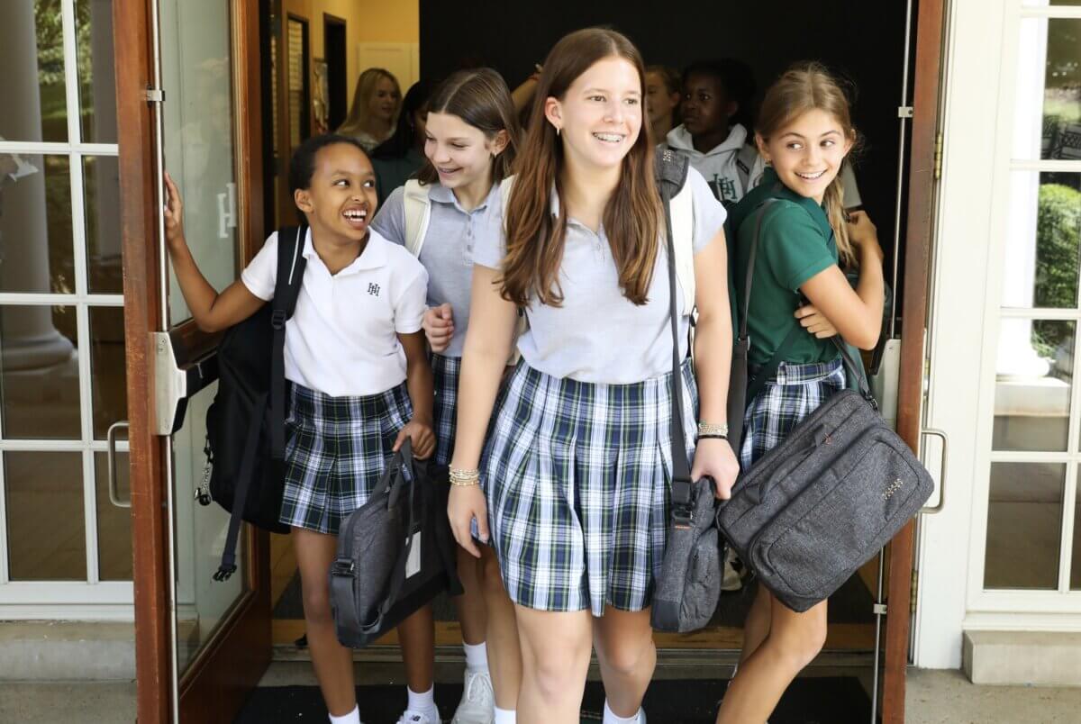 Nashville Private School Open House Dates - 8 A group of students exit a building carrying bags and smiling.