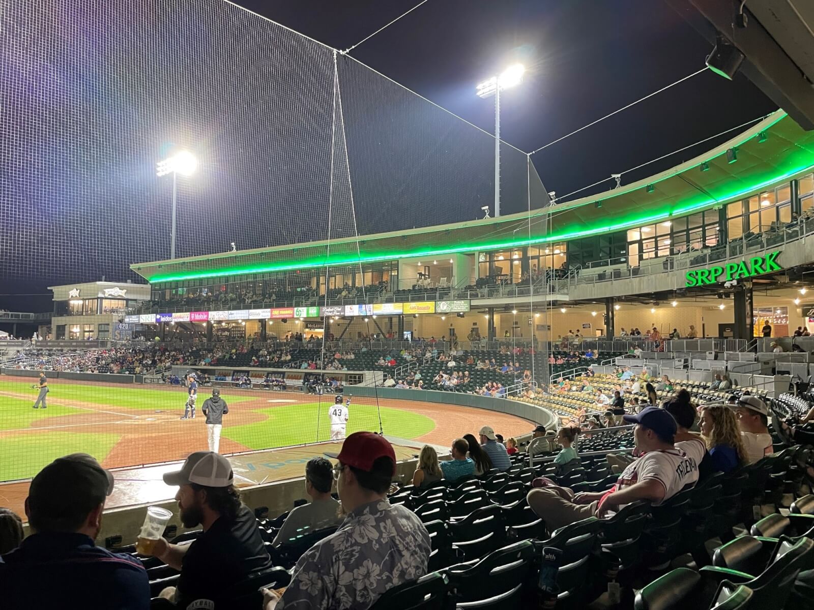 7 Best Family Vacations for Outdoor Fun - 21 A nighttime baseball game at SRP Park offers outdoor fun for the whole family, with players on the field and spectators in the stands. Stadium lights illuminate the area, and the field is bordered by a green-lit building, making it an ideal stop on your best vacations itinerary.