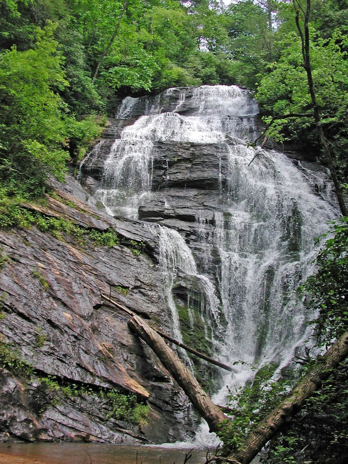 6 Southern Outdoor Getaways for the Adventure Traveler - 12 A tall waterfall cascades over layered rock formations, embraced by lush green trees and vegetation—an ideal spot for an adventure traveler seeking Southern Outdoor Getaways.