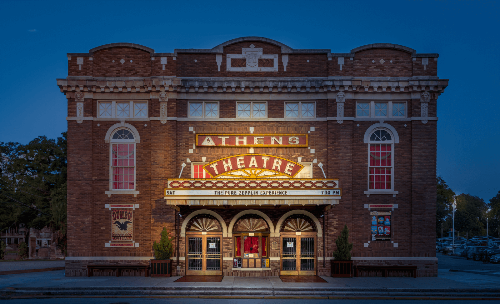 6 Southern Outdoor Getaways for the Adventure Traveler - 15 Front view of the historic brick Athens Theatre with its illuminated marquee. The entrance, perfect for an adventure traveler seeking Southern charm, boasts arched windows and double doors. Trees line the sidewalk at dusk, inviting passersby to a unique outdoor adventure.