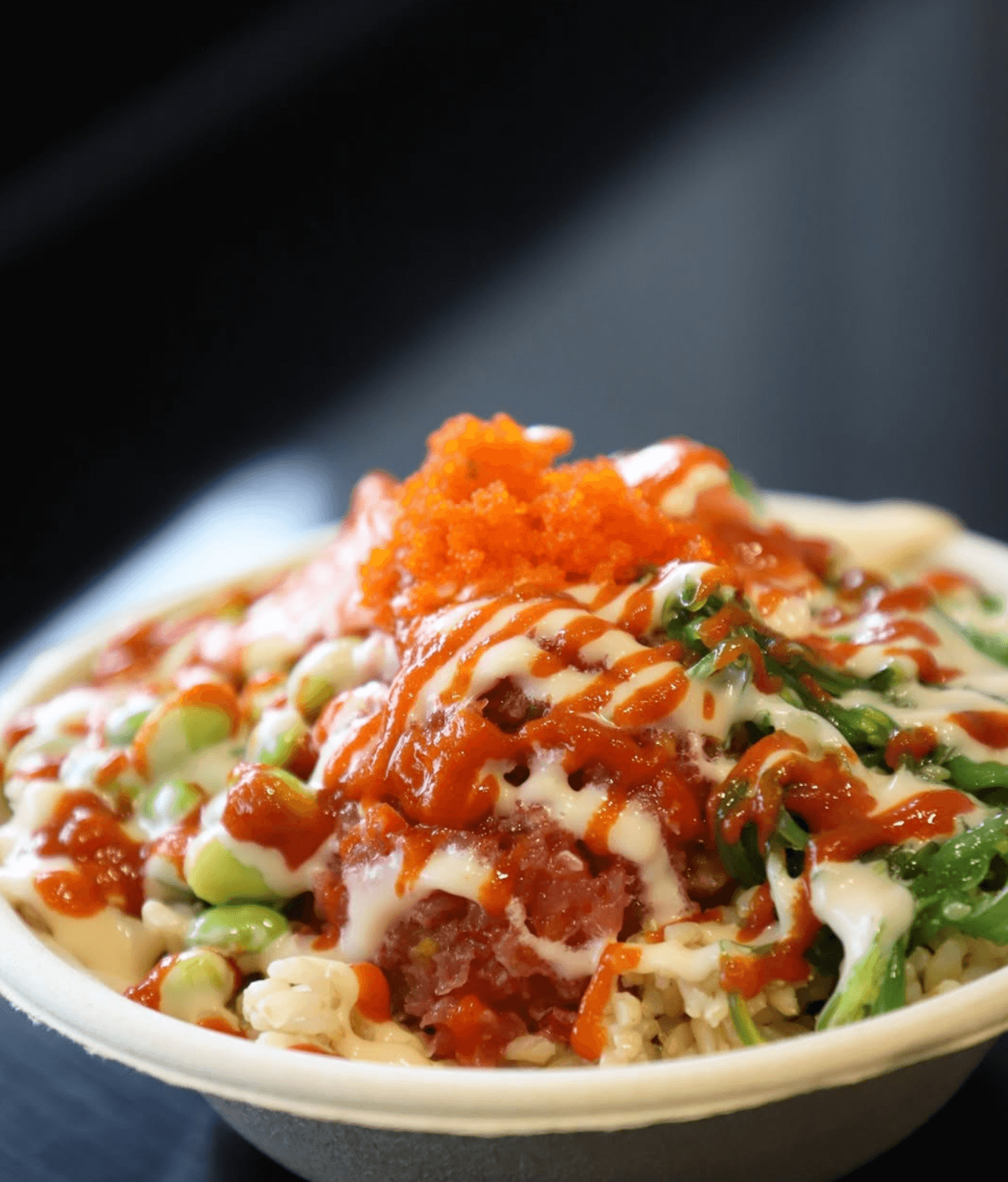 Discover Birmingham's exciting new restaurant concept: a bowl of poke featuring diced raw fish, edamame, seaweed salad, rice, and topped with vibrant orange fish roe and sauces.