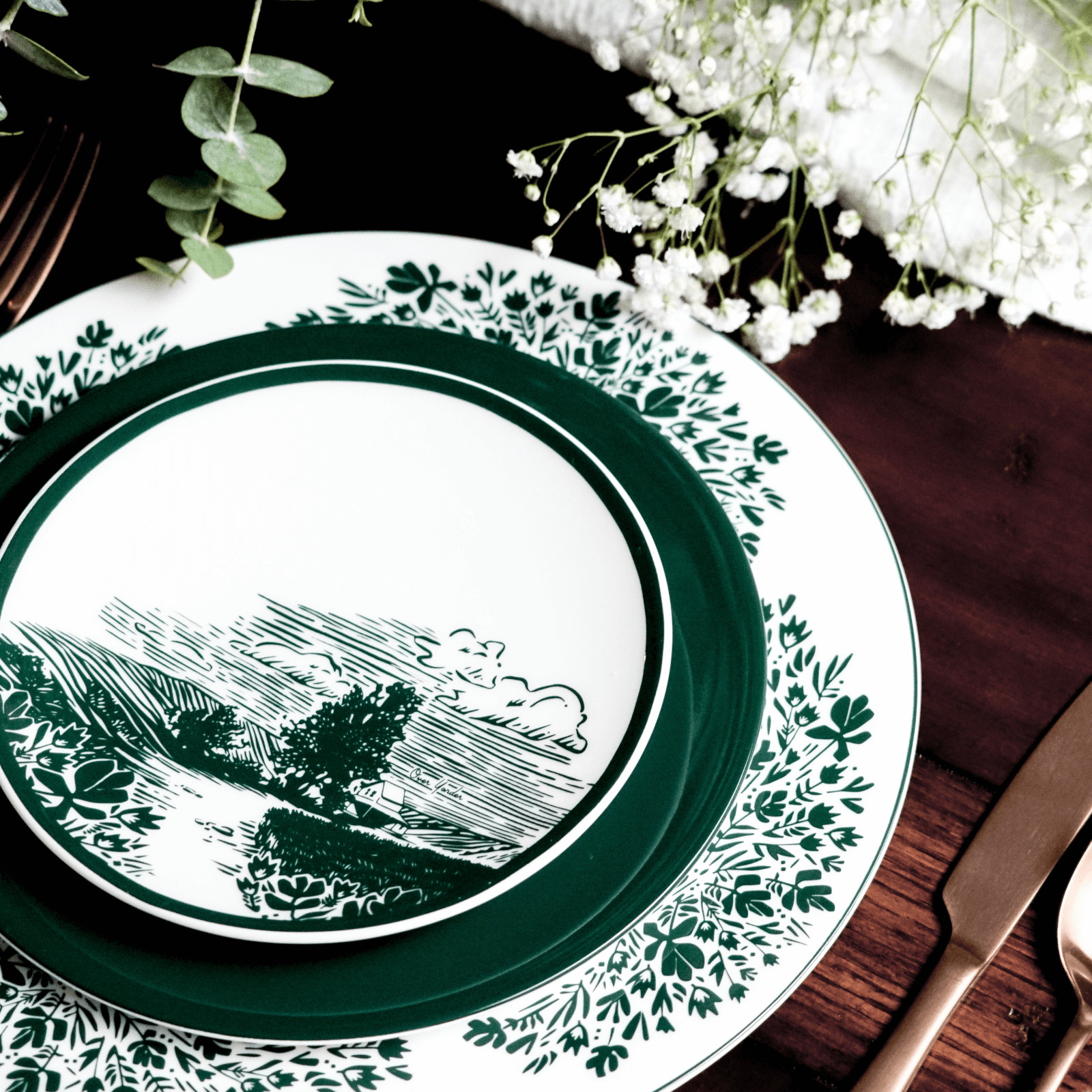 dinnerware set with green design styled with baby's breath and eucalyptus