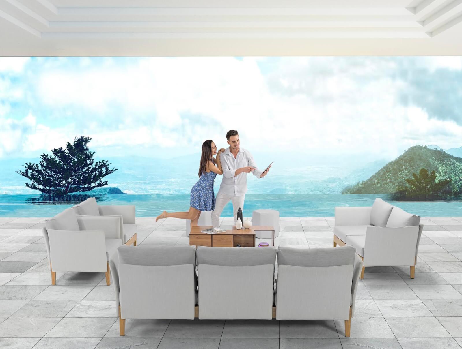 A man and woman happily explore the best home and gift stores in Birmingham on their tablet, all while enjoying a modern outdoor seating area with a scenic mountain and water view.