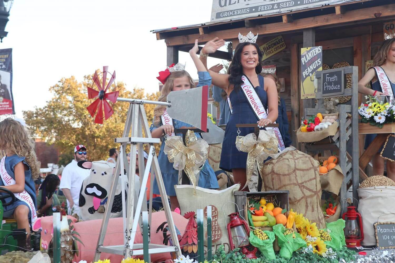 The Best Festivals in the South - 21 Women and children in sashes and crowns stand and wave on a parade float adorned with produce and farm-themed items, embodying the spirit of the South's best festivals.